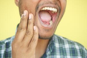 joven hombre con sensible dientes foto