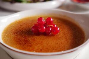 Caramel custard pudding in a bowl on table photo