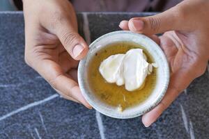 butter cream and honey in a bowl on table . photo