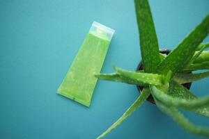 Aloe vera fresco en rodajas y gel líquido en un recipiente de plástico sobre fondo blanco. foto