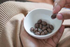 woman hand pick round shape chocolate candy in a bowl photo