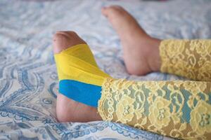 elástico terapéutico azul cinta aplicado a niño pierna. kinesio grabando terapia para lesión foto