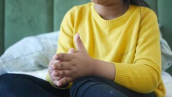 child clapping hands and smiling, sitting on sofa . video