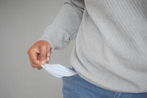 young man shows empty pant pocket with copy space photo