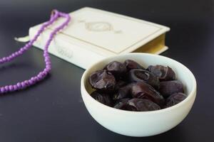 Holy book Quran and rosary on table, close up. photo