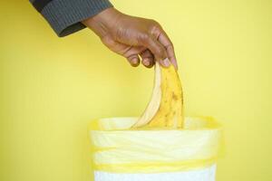 throwing banana in a garbage bin photo