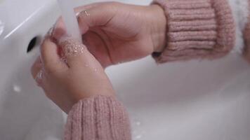 child making a cleansing gesture with soap and water on hands video