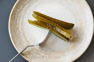 a close up of a pickle on a plate with tomatoes photo