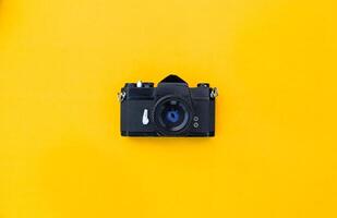 Flat lay vintage camera and film on yellow background photo