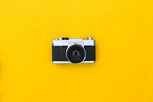 Flat lay vintage camera and film on yellow background photo