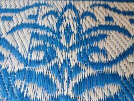 Blue and white woven mat with motif designs on it photo