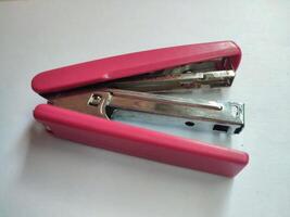 Pink stapler isolated on white background photo