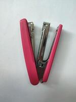 Pink stapler isolated on white background photo