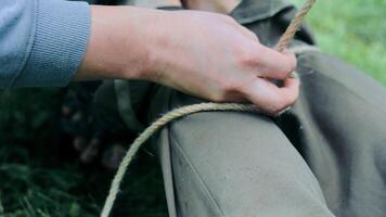 vetersluiting omhoog laarzen in de veld, detailopname van handen vetersluiting omhoog laarzen met een duurzaam touw. video