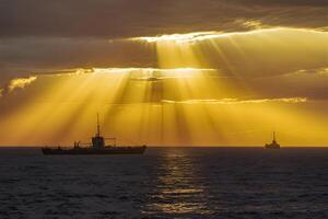 AI generated Dramatic sunset over North Sea bathed in golden sunbeams photo