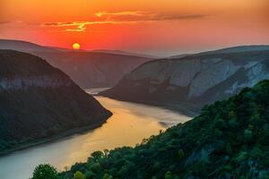 ai generado puesta de sol pinturas Danubio garganta en djerdap, serbia, con dorado ligero foto