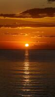 AI generated Dazzling sunset casts a golden glow over the tranquil sea Vertical Mobile Wallpaper photo