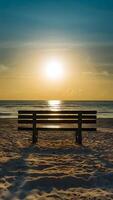 AI generated Bench bathed in sunlight offers a serene spot on the beach Vertical Mobile Wallpaper photo