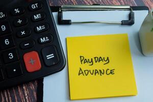 Concept of Payday Advance write on sticky notes isolated on Wooden Table. photo