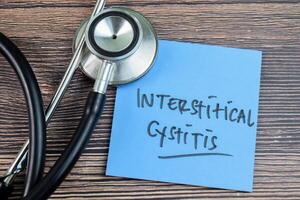 Concept of Interstitical Cytitis write on sticky notes with stethoscope isolated on Wooden Table. photo