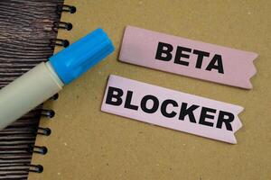 Concept of Beta Blocker write on sticky notes isolated on Wooden Table. photo