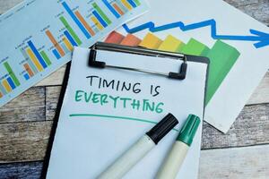 Concept of Timing is Everything write on paperwork isolated on wooden background. stock market concept photo