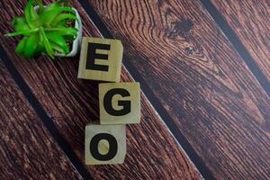 Concept of The wooden Cubes with the word EGO on wooden background. photo