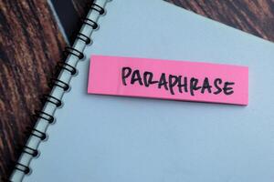 Concept of Paraphrase write on sticky notes isolated on Wooden Table. photo