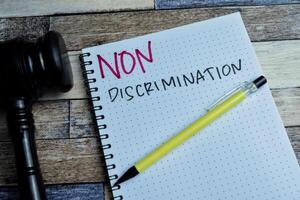 Concept of Non Discrimination write on book isolated on Wooden Table. photo