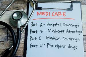 Concept of Medicare write on paperwork with stethoscope isolated on wooden background. photo