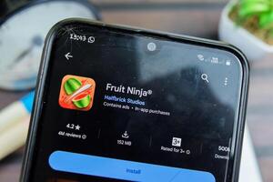 Fruit Ninja application on Smartphone screen. Fruit Ninja is a freeware web browser developed by Halfbrick Studios. Bekasi, Indonesia, March 24, 2024 photo