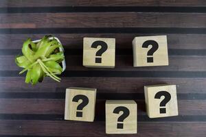 Concept of The wooden Cubes with the word Question Marks on wooden background. photo