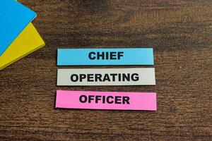 Concept of Chief Operating Officer write on sticky notes isolated on Wooden Table. photo