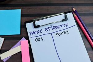 Concept of Phone Etiquette Do's and Don't's write on paperwork isolated on wooden background. photo