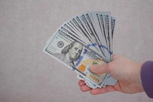 Female hands holding dollars banknotes on a grey background. photo