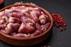 Raw chicken hearts with salt, spices and herbs photo