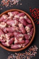 Raw chicken hearts with salt, spices and herbs photo