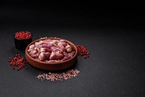 Raw chicken hearts with salt, spices and herbs photo