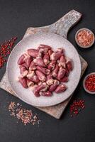 Raw chicken hearts with salt, spices and herbs photo