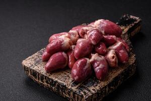 Raw chicken hearts with salt, spices and herbs photo