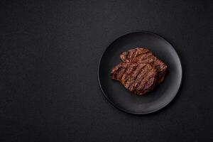 Fresh juicy delicious beef steak on a dark background photo