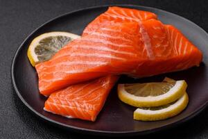 Fresh raw salmon steak with spices and herbs prepared for grilled baking photo