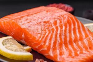 Fresh raw salmon steak with spices and herbs prepared for grilled baking photo