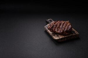 Fresh juicy delicious beef steak on a dark background photo