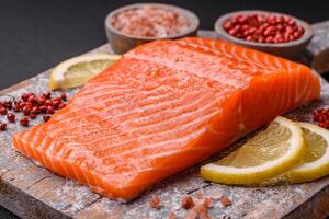 Fresh raw salmon steak with spices and herbs prepared for grilled baking photo