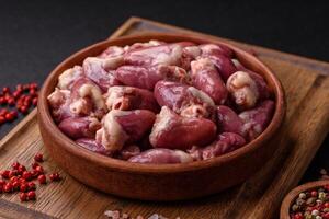 Raw chicken hearts with salt, spices and herbs photo