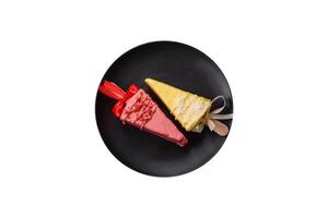 Delicious sweet cheesecake with fruits covered with icing with a wooden stick photo