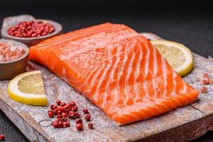 Fresh raw salmon steak with spices and herbs prepared for grilled baking photo