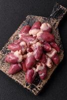 Raw chicken hearts with salt, spices and herbs photo