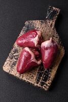 Raw turkey or chicken hearts with salt and spices photo